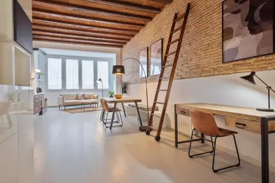 a loft apartment with a brick wall and ladder at Alcam Gracia in Barcelona
