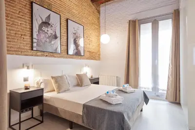 a bedroom with a large bed and a large window at Alcam Gracia in Barcelona