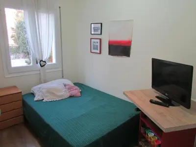 a bedroom with a bed and a television on a desk at Acogedor apartamento en el centro de Sitges in Sitges