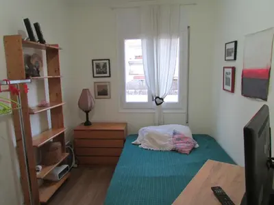 a small bedroom with a bed and a window at Acogedor apartamento en el centro de Sitges in Sitges