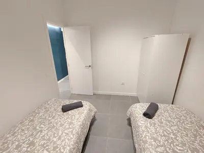 two beds in a room with white walls and white cabinets at Charming apartment Poblenou beach in Barcelona