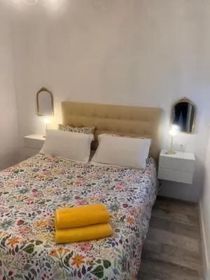 a bedroom with a bed with a yellow towel on it at Atico 1º linea vistas Sitges in Sitges