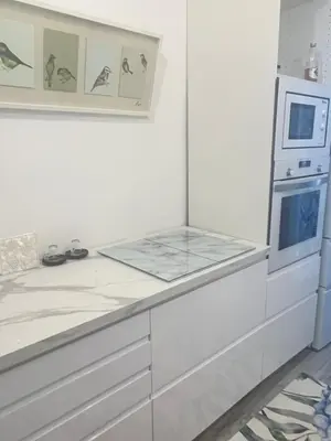 a white kitchen with a counter and a microwave at Atico 1º linea vistas Sitges in Sitges