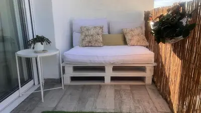 a small bed on a balcony with a table at Atico 1º linea vistas Sitges in Sitges