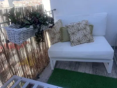a white bench on a balcony with a potted plant at Atico 1º linea vistas Sitges in Sitges