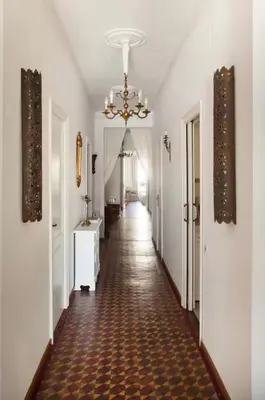 a hallway with a long corridor with a chandelier at Céntrico y espacioso apartamento in Barcelona