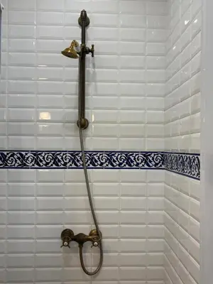 a shower with a hose in a white tiled bathroom at Céntrico y espacioso apartamento in Barcelona