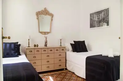 a bedroom with two beds and a dresser with a mirror at Céntrico y espacioso apartamento in Barcelona