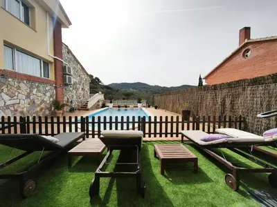a patio with chairs and a pool with a fence at Luxury Villa in Vallromanes - Mountain Views, Pool, Close to Barcelona and the Beach in Vallromanas