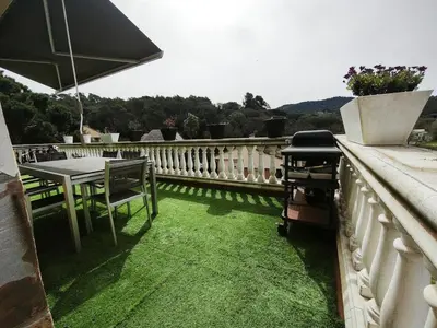 a table and chairs on a balcony with grass at Luxury Villa in Vallromanes - Mountain Views, Pool, Close to Barcelona and the Beach in Vallromanas