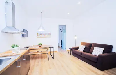 a kitchen and a living room with a couch at Central apartment in Sant Antoni in Barcelona