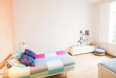 a bedroom with a bed with colorful pillows at Central apartment in Sant Antoni in Barcelona
