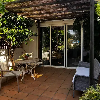 a patio with a table and chairs and glass doors at Estudio limonero en Sant Cebriá de Vallalta 20' playa in Sant Cebrià de Vallalta