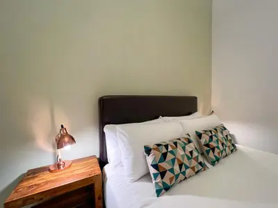 a bed with a lamp on a table next to it at Stay U-nique Apartments Comte Urgell in Barcelona