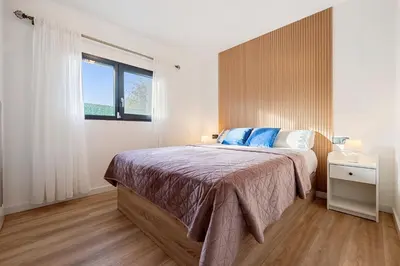 a bedroom with a large bed and a window at Hauzify I Casa Somella in Vilanova i la Geltrú