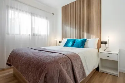 a bedroom with a large bed with blue pillows at Hauzify I Casa Somella in Vilanova i la Geltrú