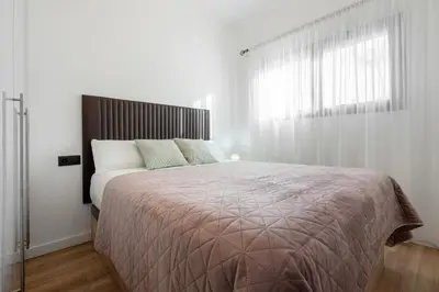 a bedroom with a large bed and a window at Hauzify I Casa Somella in Vilanova i la Geltrú