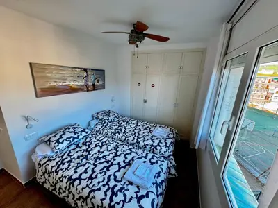 a bedroom with a bed and a ceiling fan at Apartamento Canet de Mar - Primera linea de Playa - Increibles vistas al Mar in Canet de Mar