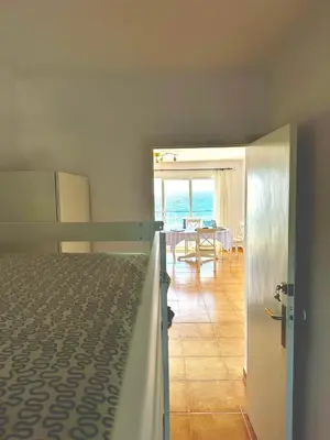 a bedroom with a bed and a dining room with the ocean at Apartamento Canet de Mar - Primera linea de Playa - Increibles vistas al Mar in Canet de Mar