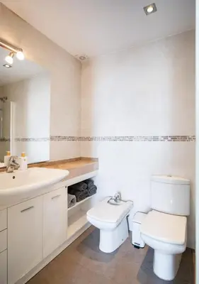 a white bathroom with a toilet and a sink at Av d'Eduard Maristany, 13 in Sant Adria de Besos