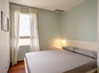 a bedroom with a white bed and a window at Av d'Eduard Maristany, 13 in Sant Adria de Besos