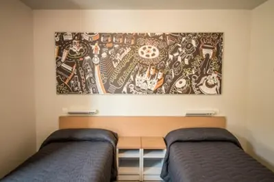 a bedroom with two beds and a painting on the wall at Barcelona Pere Tarrés Youth Hostel in Barcelona