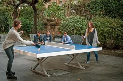a woman playing ping pong on a ping pong table at Barcelona Pere Tarrés Youth Hostel in Barcelona