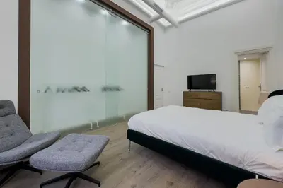 a bedroom with a bed and two chairs and a tv at Precioso apartamento en Rambla Cataluña 35 in Barcelona