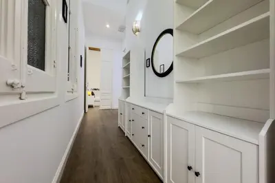 a white hallway with white cabinets and a mirror at Precioso apartamento en Rambla Cataluña 35 in Barcelona