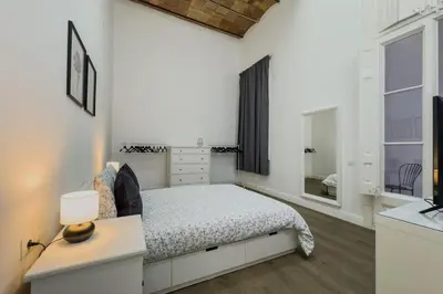 a white bedroom with a bed and a window at Precioso apartamento en Rambla Cataluña 35 in Barcelona