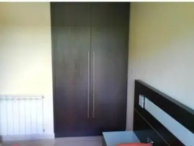 a room with a wooden cabinet and a bed at Apartamento Castellet1 in San Vicente de Castellet