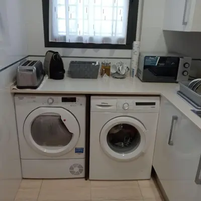 a kitchen with a washing machine and a microwave at Apartamento Castellet1 in San Vicente de Castellet