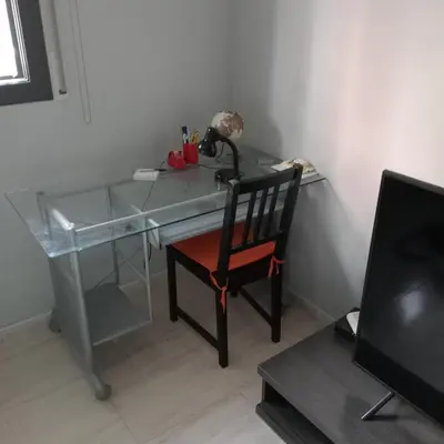 a desk with a red chair and a glass table at Apartamento Castellet1 in San Vicente de Castellet