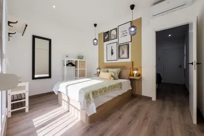 a bedroom with a large bed and a table at Precioso apartamento en Ronda Sant Pau in Barcelona