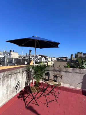 two chairs and a table with an umbrella on a patio at Precioso apartamento en Ronda Sant Pau in Barcelona