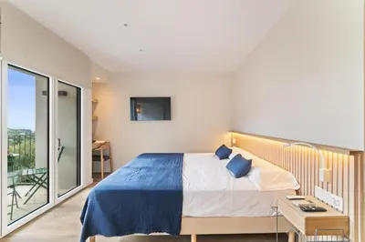 a bedroom with a bed and a balcony at L'Hostalet de Cabrils in Cabrils