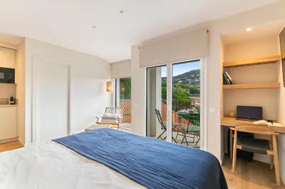a bedroom with a bed and a desk and a balcony at L'Hostalet de Cabrils in Cabrils