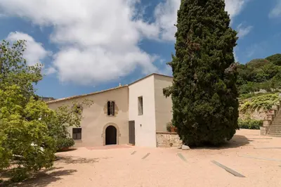 a building with a large tree in front of it at Beautiful 15th century villa on 30 acre estate, for families only in Alella