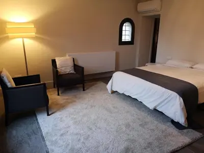 a bedroom with a bed and a chair and a window at Beautiful 15th century villa on 30 acre estate, for families only in Alella