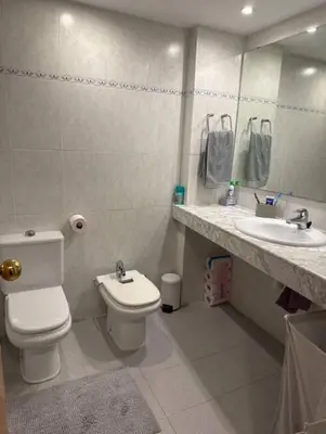 a bathroom with a toilet and a sink and a mirror at Surf&Snooze in Castelldefels