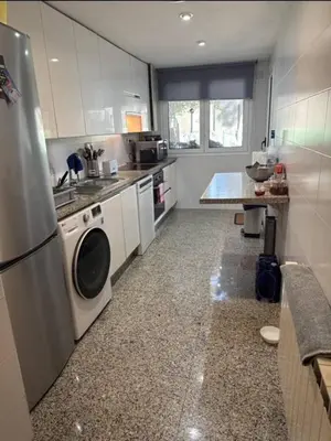 a kitchen with a refrigerator and a washing machine at Surf&Snooze in Castelldefels
