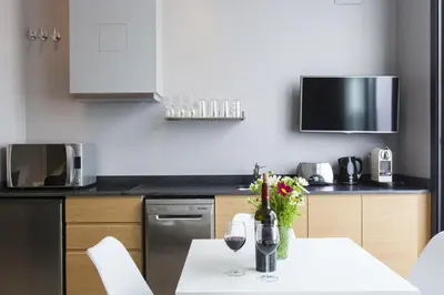a kitchen with a table with two glasses of wine at Kare No Apartments by Sitges Group in Sitges