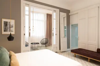 a bedroom with a bed and a couch and a window at Forget Me Not Barcelona in Barcelona