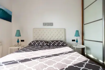 a bedroom with a large bed and two lamps at Apartment with Pool 50 meters to the beach in Castelldefels