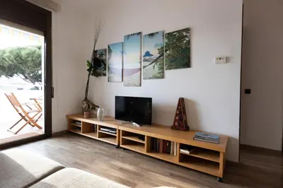 a living room with a tv on a wall at Apartment with Pool 50 meters to the beach in Castelldefels