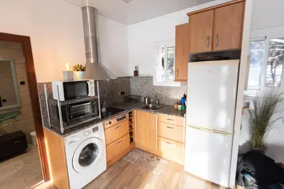 a kitchen with a refrigerator and a washing machine at Apartment with Pool 50 meters to the beach in Castelldefels