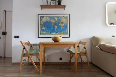 a table and chairs with a map on the wall at Apartment with Pool 50 meters to the beach in Castelldefels