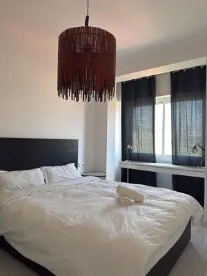 a bedroom with a large white bed with a chandelier at City Center 3 Bedroom Apartment! in Barcelona