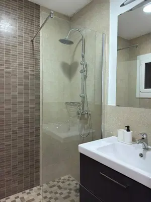 a bathroom with a shower and a sink and a sink at City Center 3 Bedroom Apartment! in Barcelona