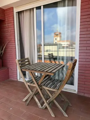 a wooden table and two chairs on a balcony at City Center 3 Bedroom Apartment! in Barcelona